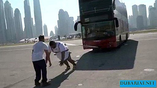 Homem forte de Dubai desliza ônibus de dois andares pesando seu corpo